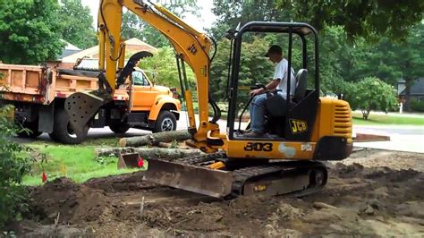 grading hill with mini excavator|digging with an excavator.